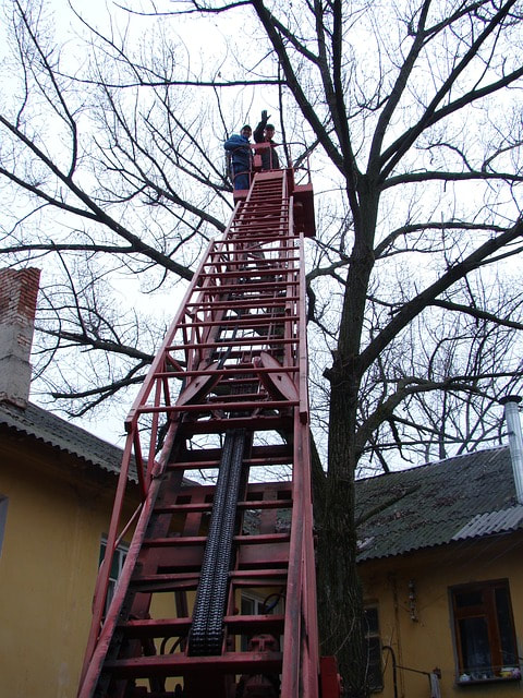 large ladder erected near a home for emergency tree trimming